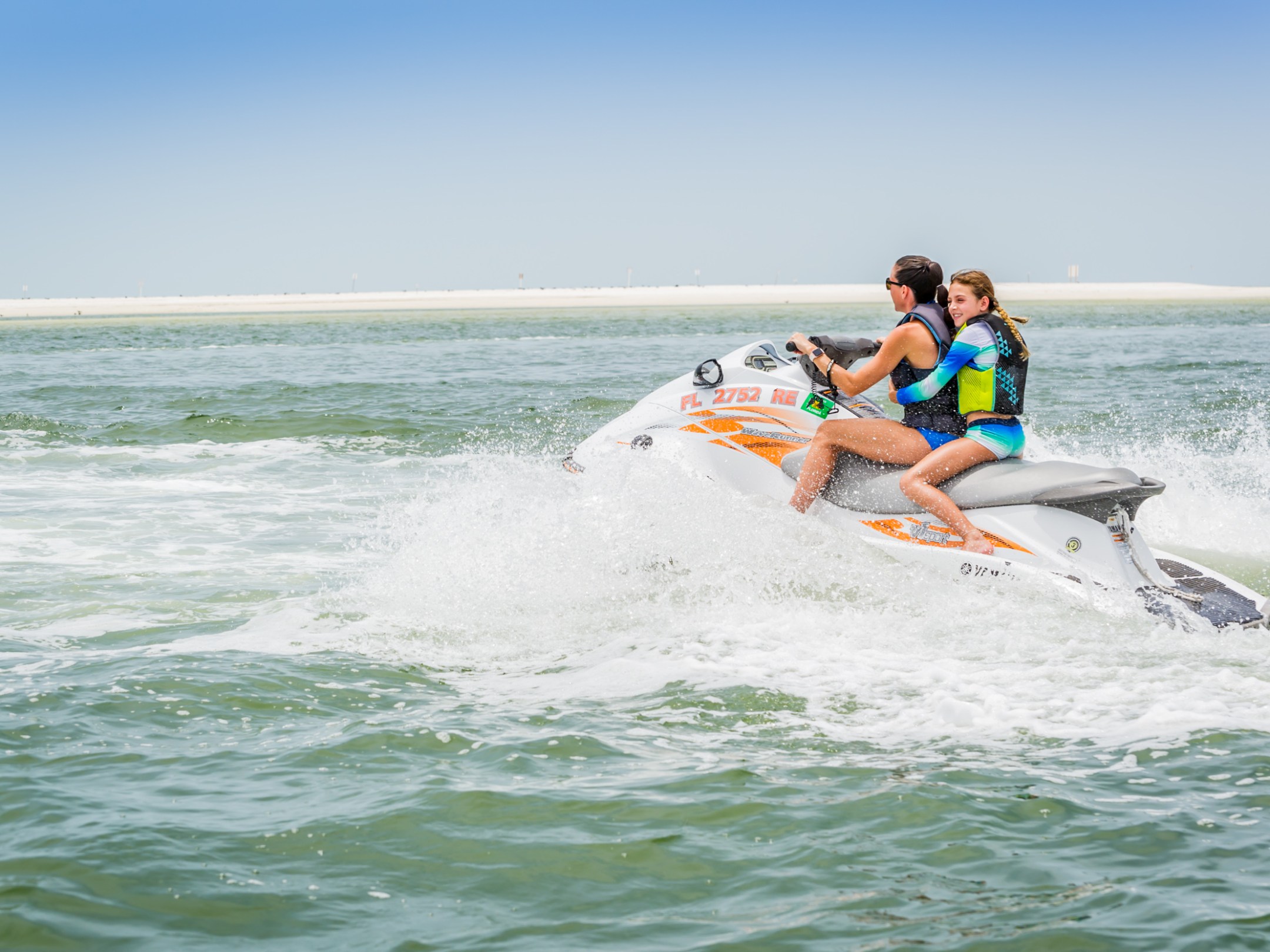 two people riding on a jet ski together in the ocean